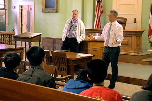 Photographs of First Circuit Judges James C. McWhinnie (left) and James H. Ashford as they speak to middle school students.