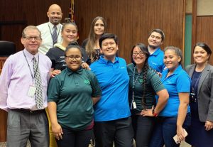 Photo of: Front row (left): District Family Court Judge Lloyd Poelman, Samantha Uu, Jason Gumbac, Sharla Fujimoto, Aponi Boyer, and District Family Court Judge Adrianne Heely. Second row (left): Ipolani Mae-Pescaia, Malia Ferriera, and Kholby Akuna. Back: Brian Raphael.