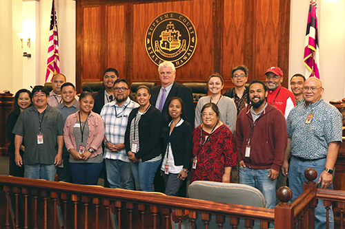 Large group of men and women posing in courtroom