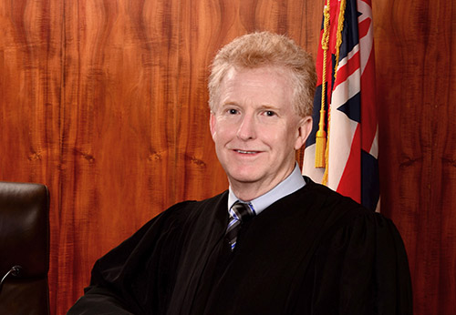 Close-up of First Circuit Chief Judge R. Mark Browning, standing in front of the courtroom bench.